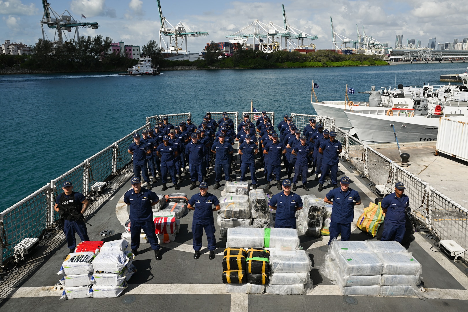 The crew members from Coast Guard Cutter Venturous pose before preparing to offload a pallet of illegal narcotics at Coast Guard Base Miami Beach, May 2, 2025. The seized contraband was the result of four interdictions in the Caribbean Sea by the crews of USCGC Diligence (WMEC-616) and HNLMS Groningen (P843) with an embarked Coast Guard law enforcement detachment. (U.S. Coast Guard photo by Petty Officer 3rd Class Jessica Walker)