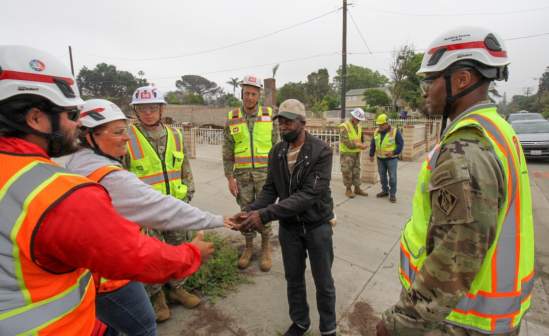 Darius Wallace, U.S. Army Corps of Engineers Los Angeles District employee and an Eaton Wildfire survivor, is greeted by USACE teammates April 30 outside his property in Altadena, California.