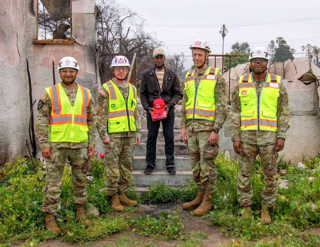 Darius Wallace, U.S. Army Corps of Engineers Los Angeles District employee and an Eaton Wildfire survivor, center, stands with USACE leaders during Wallace's property walkthrough April 30 in Altadena, California. From left to right are Col. Sonny Avichal, USACE Emergency Field Office - Eaton commander; Brig. Gen. William Hannan Jr., commander of USACE Southern California Wildfires Debris Recovery Mission - Task Force Phoenix; Wallace; Col. Andrew Baker, USACE LA District commander; and Lt. Col. Stephen Brooks, USACE LA District deputy commander. The leaders were there to show their continuing support to Wallace, who served with the LA District for 43 years.