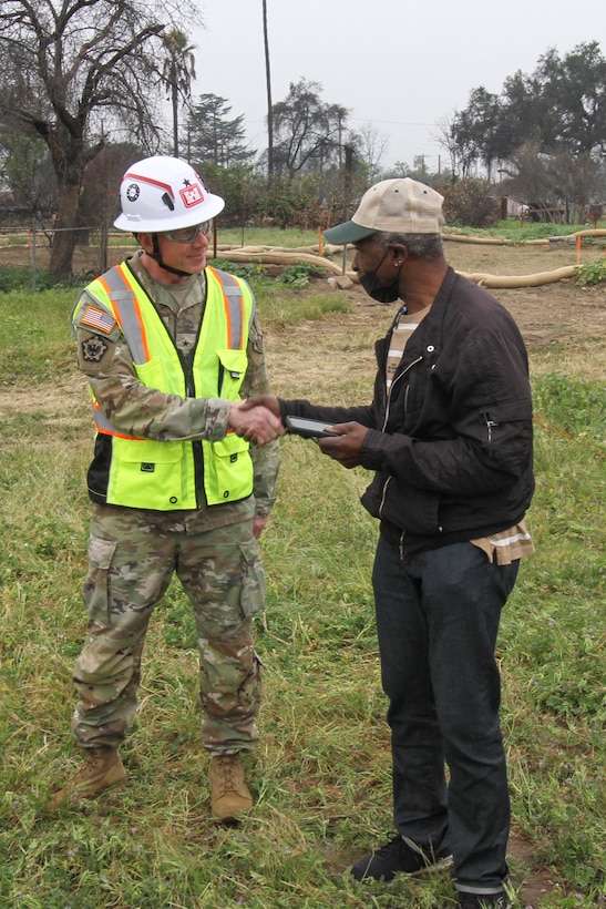 Darius Wallace, U.S. Army Corps of Engineers Los Angeles District employee and an Eaton Wildfire survivor, right, shakes hands with Brig. Gen. William Hannan Jr., commander of USACE Southern California Wildfires Debris Recovery Mission - Task Force Phoenix, after a walkthrough of Wallace's property April 30 in Altadena, California.