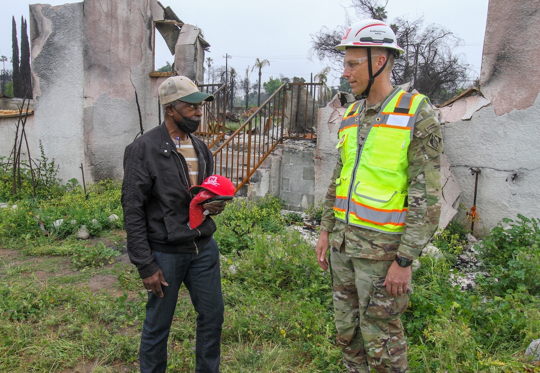 Darius Wallace, U.S. Army Corps of Engineers Los Angeles District employee and an Eaton Wildfire survivor, left, talks with Col. Andrew Baker, LA District commander, right, during a property inspection April 30 in Altadena, California. Baker and fellow USACE leaders were there to offer their continuing support.