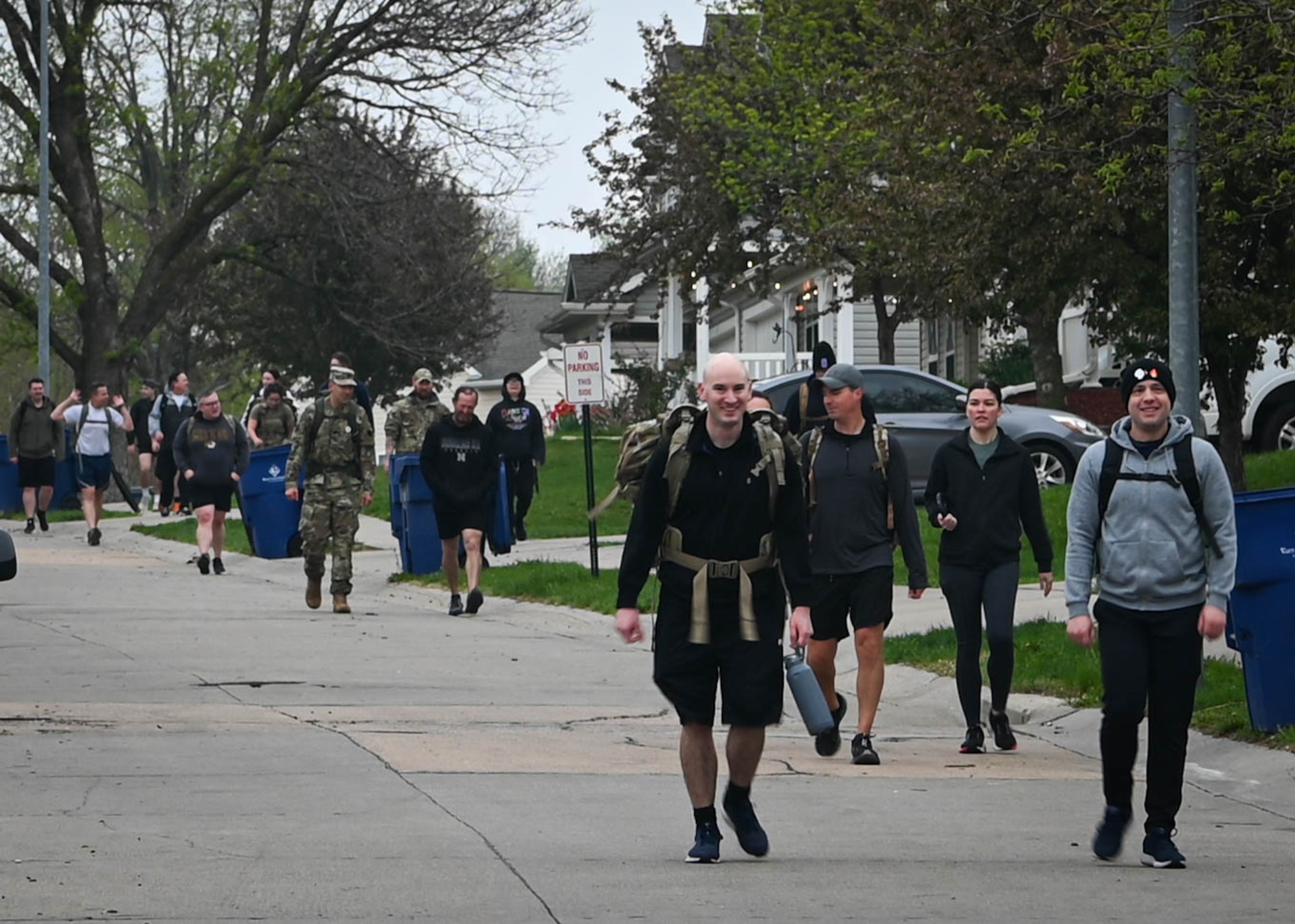 Airmen march through the Coffman Heights neighborhood during a ruck march memorializing Capt. Nathan Nylander, a 25th Operational Weather Squadron weather officer killed in Afghanistan in 2011, on Offutt Air Force Base, Nebraska, April 25, 2025. More than 50 Airmen participated in the event. (U.S. Air Force photo by Daniel Martinez)