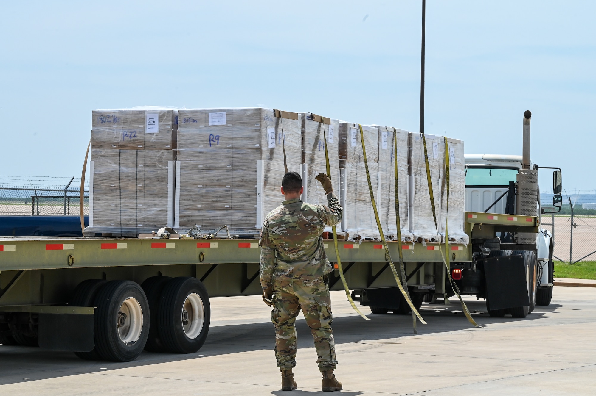 U.S. Air Force Senior Airman Joshua Sandoval, 7th Logistics Readiness Squadron ground transportation operator, directs a truck to unload food supplies for the Denton Program on Dyess Air Force Base, Texas, April 28, 2025. The Denton Program allows private U.S. citizens and organizations to use space available on U.S. military cargo planes to transport humanitarian goods. (U.S. Air Force photo by Airman 1st Class Adrien Tran)