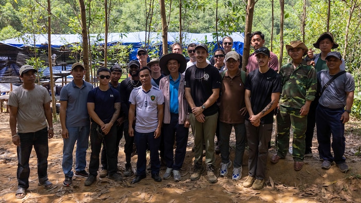 Tech. Sgt. Joshua Sims, an Explosive Ordnance Disposal technician assigned as a Defense POW/MIA Accounting Agency short term individual augmentee, and the DPAA Accounting Agency recovery team, Vietnamese Office for Seeking Missing Persons officials, and local Vietnamese workers pose for a photo after completing recovery operations in Vietnam on April 11, 2025.