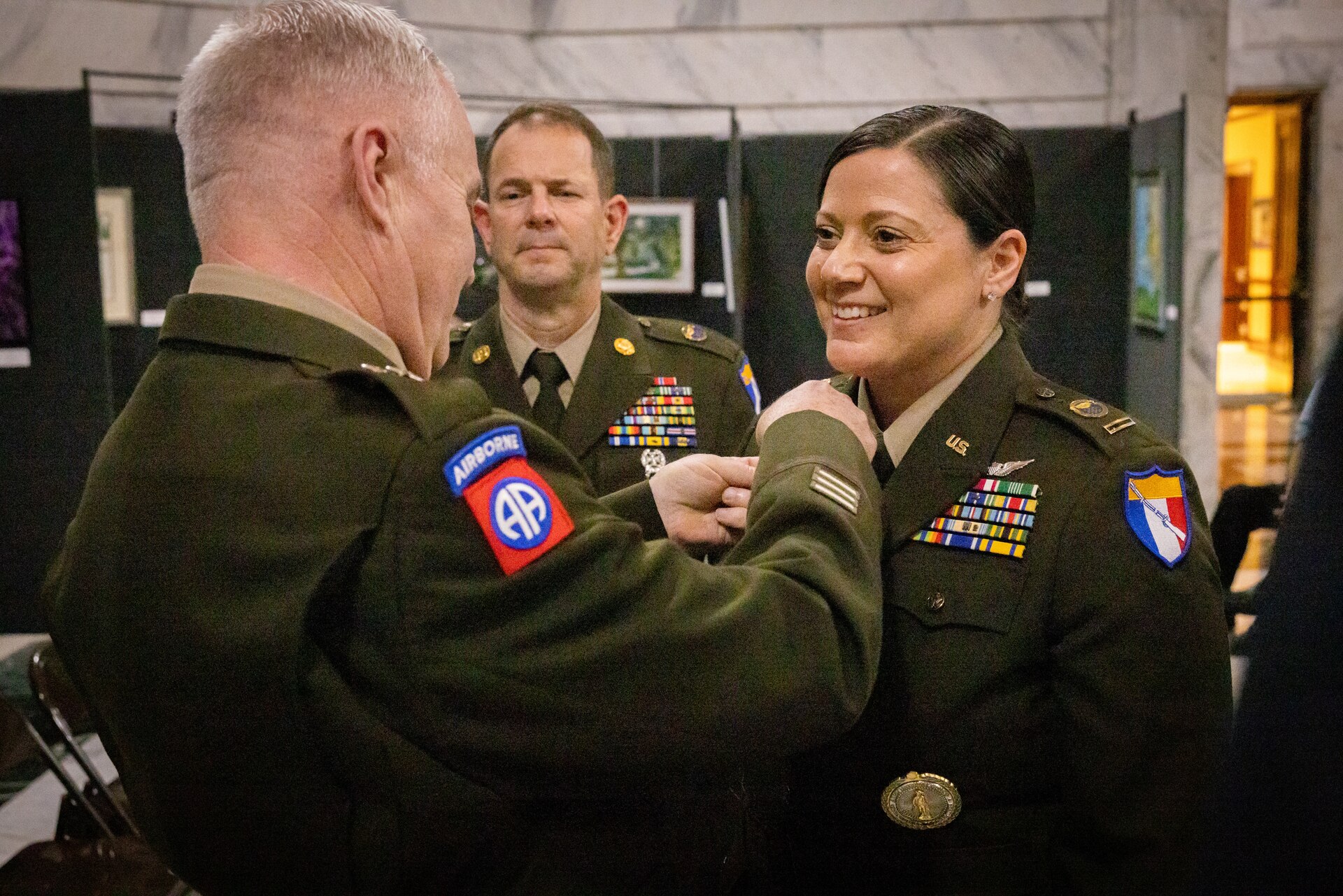 U.S. Army Chief Warrant Officer 5 Jennifer Ritchie smiles as Maj. Gen. Haldane Lamberton, Kentucky’s adjutant general, places the command chief warrant officer insignia on Ritchie's uniform at the command chief warrant officer change of responsibility at the State Capitol Rotunda in Frankfort, Ky. on April 29, 2025. Ritchie was appointed as the Kentucky Army National Guard command chief warrant officer during the ceremony, held previously by Chief Warrant Officer 5 Rickey Skelton. (U.S. Army photo by Andy Dickson)