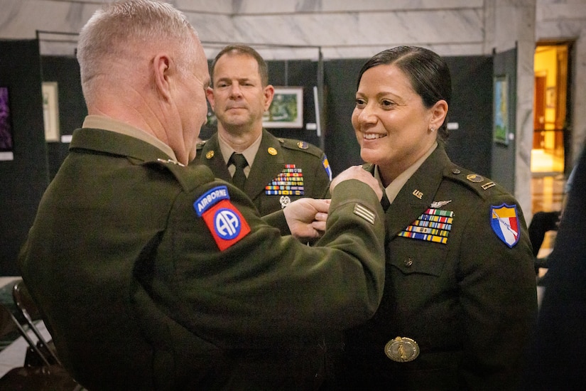 U.S. Army Chief Warrant Officer 5 Jennifer Ritchie smiles as Maj. Gen. Haldane Lamberton, Kentucky’s adjutant general, places the command chief warrant officer insignia on Ritchie's uniform at the command chief warrant officer change of responsibility at the State Capitol Rotunda in Frankfort, Ky. on April 29, 2025. Ritchie was appointed as the Kentucky Army National Guard command chief warrant officer during the ceremony, held previously by Chief Warrant Officer 5 Rickey Skelton. (U.S. Army photo by Andy Dickson)