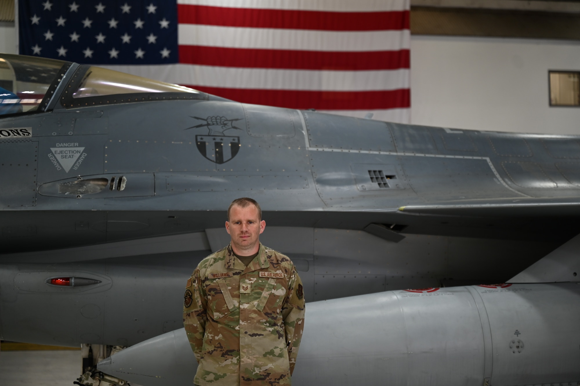 U.S. Air National Guardsman Tech. Sgt. Burney Williams, 113th Maintenance Squadron aircraft mechanic, poses in front of an F-16 at Joint Base Andrews, Maryland, May 3, 2025
