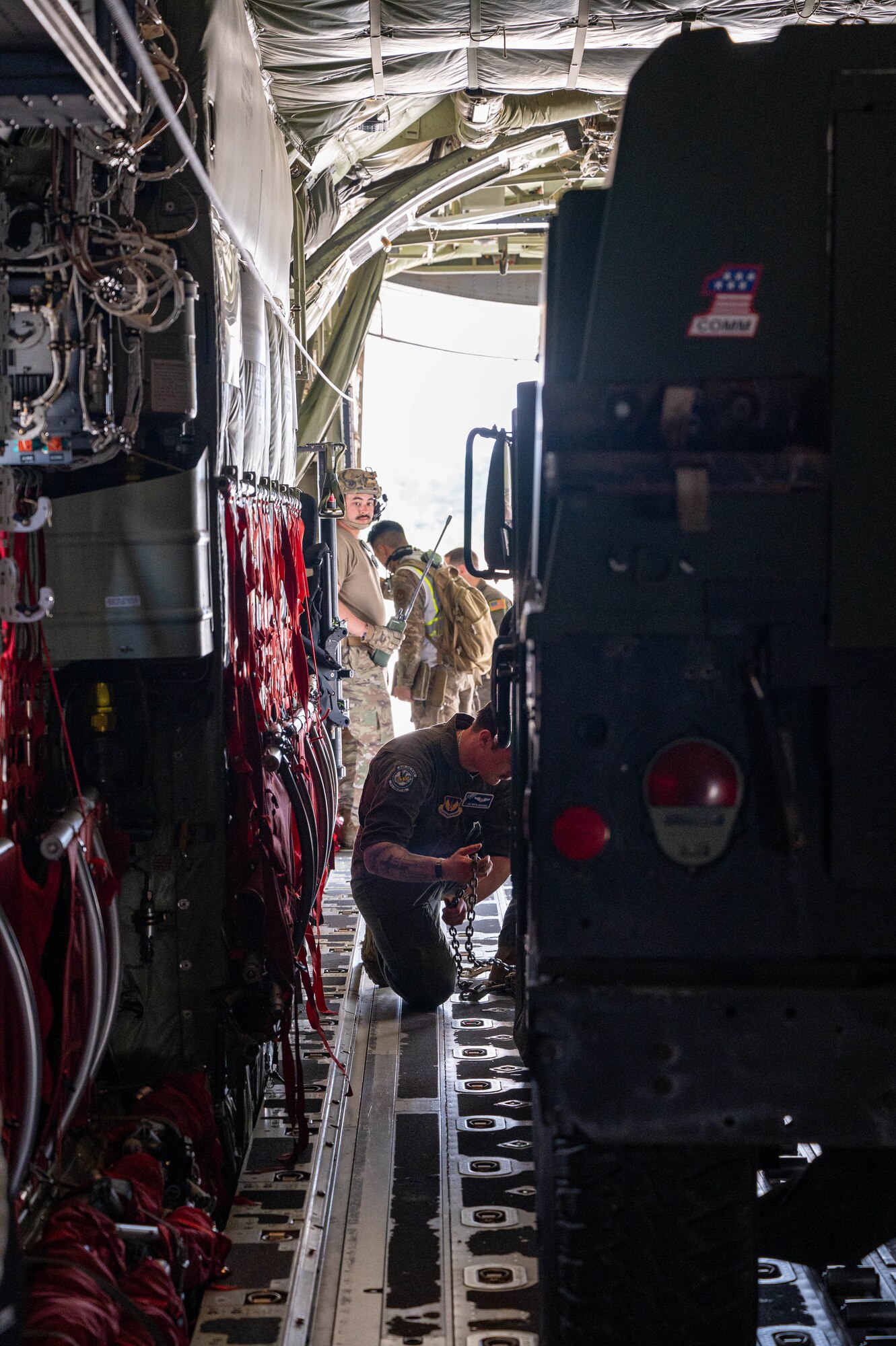 U.S. Airmen secure cargo to an aircraft