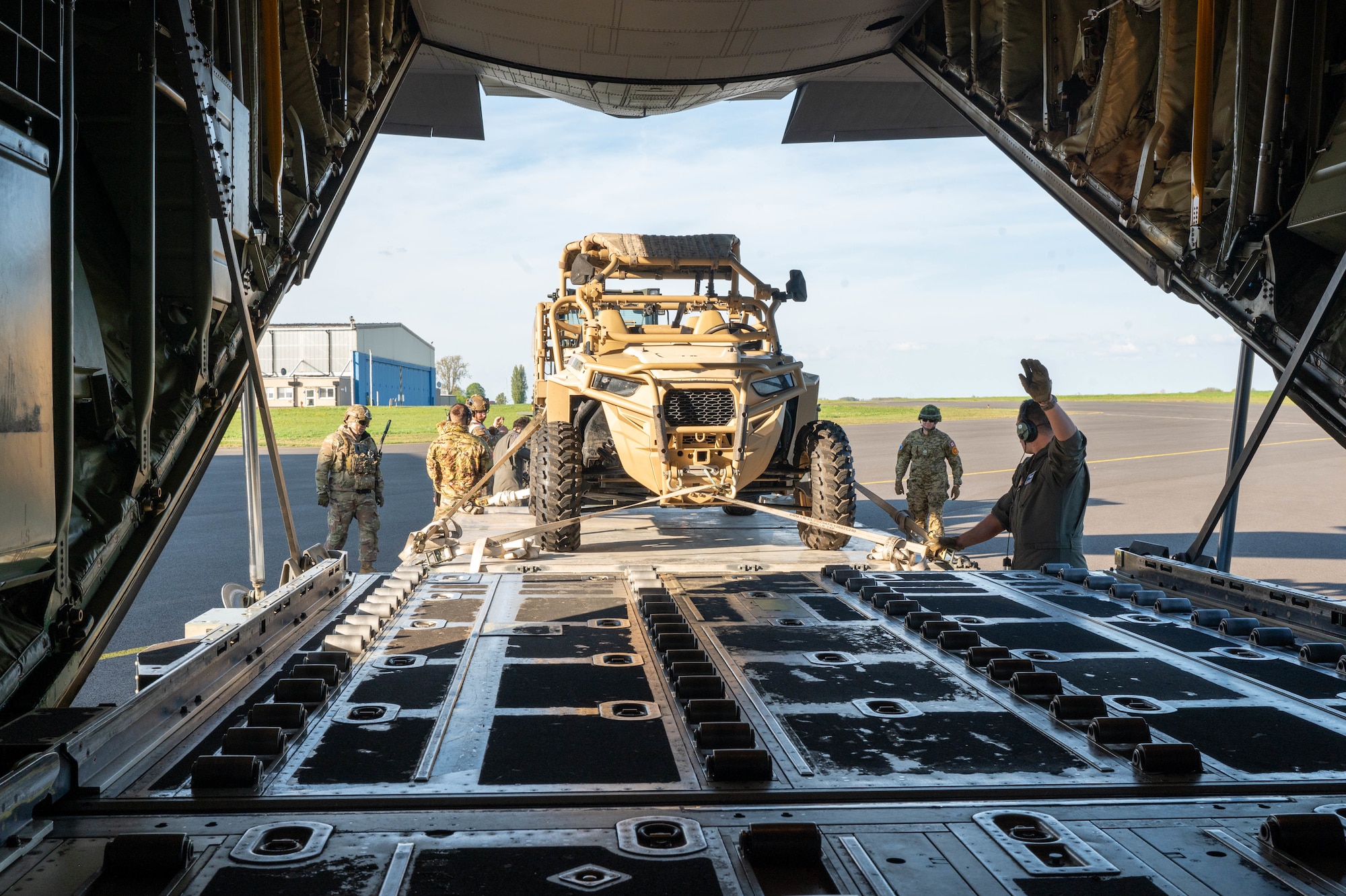 U.S. Airmen offload a light tactical all-terrain vehicle from an aircraft