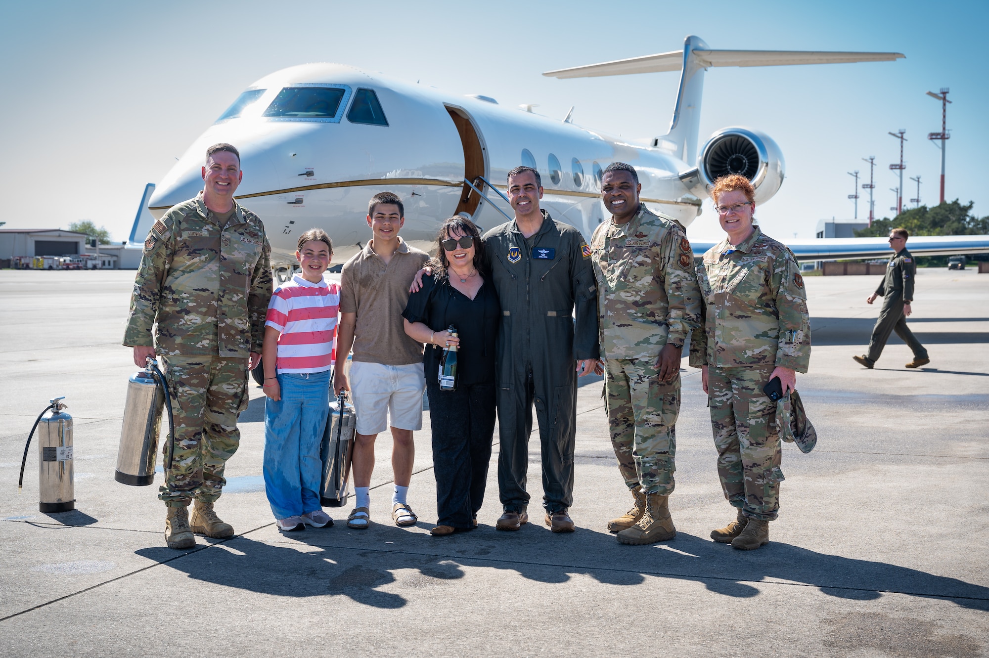 U.S. Air Force Col. Jamil I. Musa, 86th Airlift Wing deputy commander, poses for a photo with his family and Kaiserslautern Military Community leadership after his “fini flight” at Ramstein Air Base, Germany, April 29, 2025. A “fini flight” is a tradition within the U.S. Air Force where a pilot or crew members are celebrated with a water salute upon completion of their final flight at a particular unit or upon retirement. Musa is a command pilot with more than 3,000 flying hours. (U.S. Air Force photo by Senior Airman Jared Lovett)