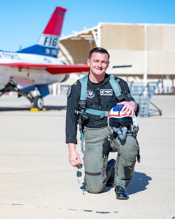 Maj. Hiester kneels in front of his aircraft to pose for a photo.