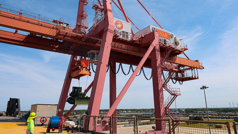 A U.S. Marine Corps Maritime Prepositioning Force crawler dozer aboard the United States Naval Ship Seay (T-AKR 302) Is hoisted off using a gantry crane in preparation for the Maritime Prepositioning Force Maintenance Cycle (MMC) 14 at Marine Corps Support Facility Blount Island.