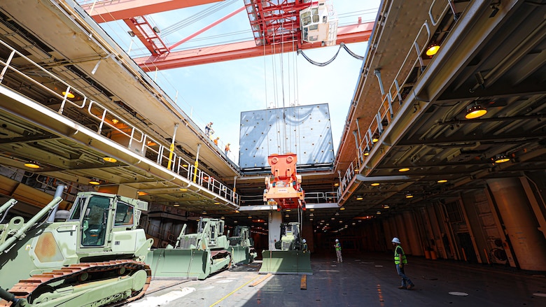 A U.S. Marine Corps Maritime Prepositioning Force crawler dozer aboard the United States Naval Ship Seay (T-AKR 302) Is hoisted off using a gantry crane in preparation for the Maritime Prepositioning Force Maintenance Cycle (MMC) 14 at Marine Corps Support Facility Blount Island.