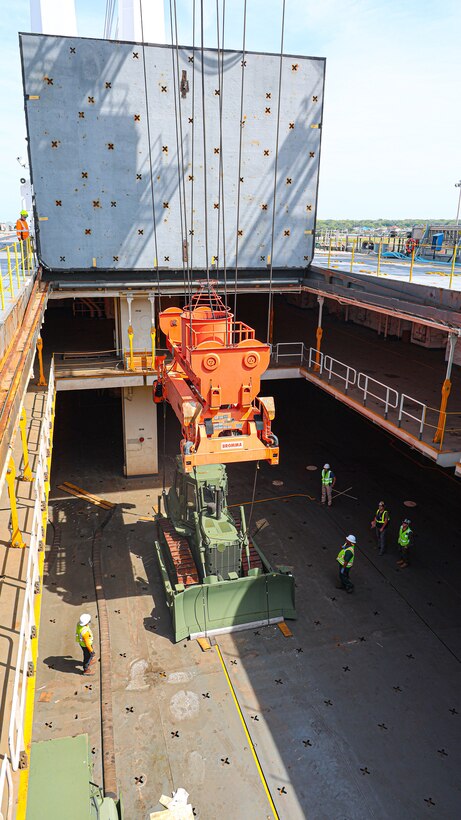 A U.S. Marine Corps Maritime Prepositioning Force crawler dozer aboard the United States Naval Ship Seay (T-AKR 302) Is hoisted off using a gantry crane in preparation for the Maritime Prepositioning Force Maintenance Cycle (MMC) 14 at Marine Corps Support Facility Blount Island.