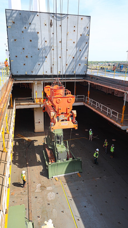 A U.S. Marine Corps Maritime Prepositioning Force crawler dozer aboard the United States Naval Ship Seay (T-AKR 302) Is hoisted off using a gantry crane in preparation for the Maritime Prepositioning Force Maintenance Cycle (MMC) 14 at Marine Corps Support Facility Blount Island.