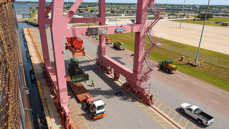 A U.S. Marine Corps Maritime Prepositioning Force crawler dozer aboard the USNS Seay (T-AKR 302) is hoisted off using a gantry crane in preparation for the Maritime Prepositioning Force Maintenance Cycle (MMC) 14 at Marine Corps Support Facility Blount Island in Florida.