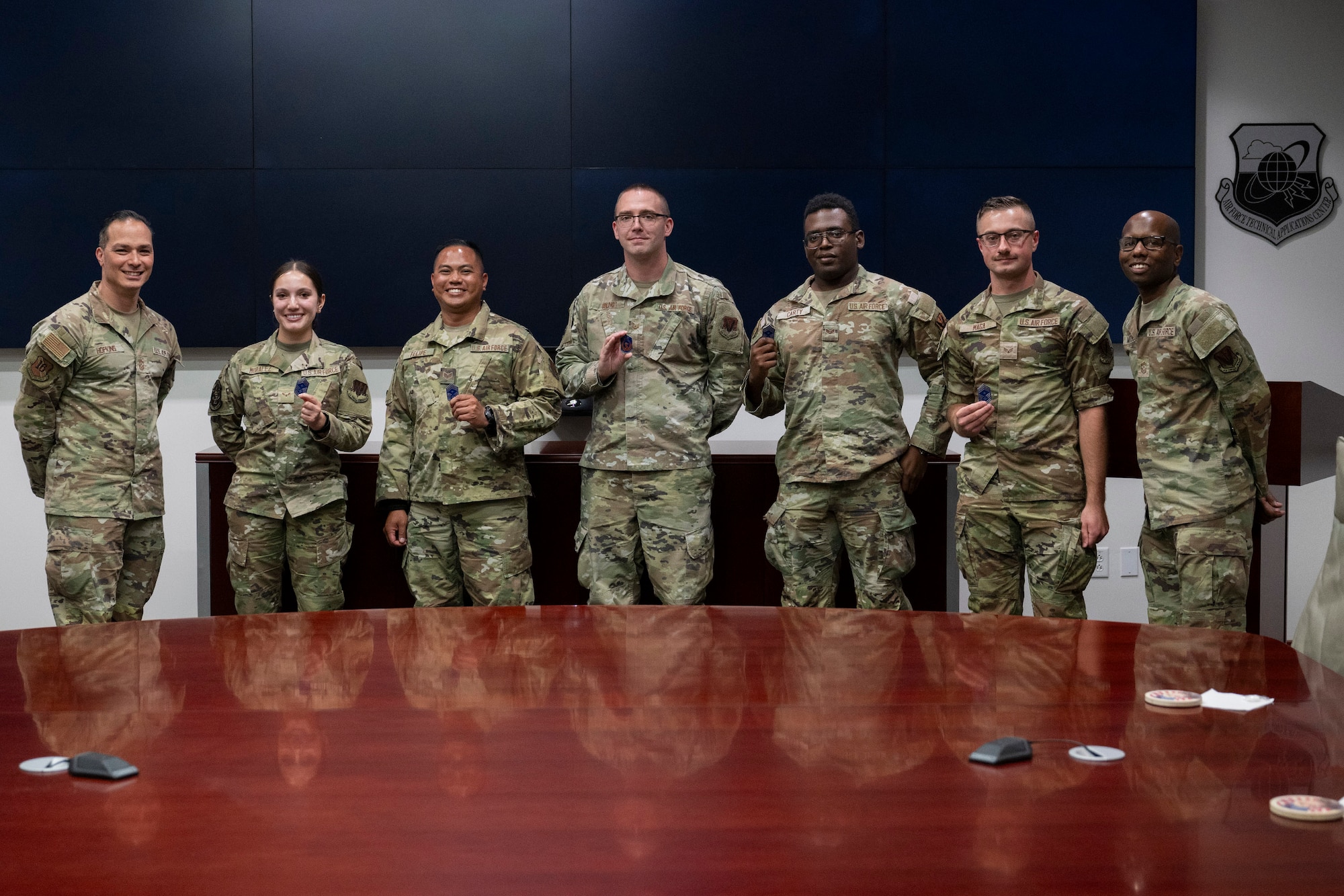 Chief Master Sgt. Robert Hopkins (left), 16th Air Force Command Chief, presents his military challenge coin to several members of the Air Force Technical Applications Center for superior performance during his visit to Patrick Space Force Base, Fla., April 17-18, 2025.  Pictured from left to right:  Hopkins, Airman 1st Class Kristina Moralez, Staff Sgt. Daniel Felipe, Tech. Sgt. Brian Ebling, Senior Airman Alexander Carty, Senior Airman Zachary Maga, and AFTAC’s Command Chief, Chief Master Sgt. Brian Mitchell.  (U.S. Air Force photo by Matthew S. Jurgens)