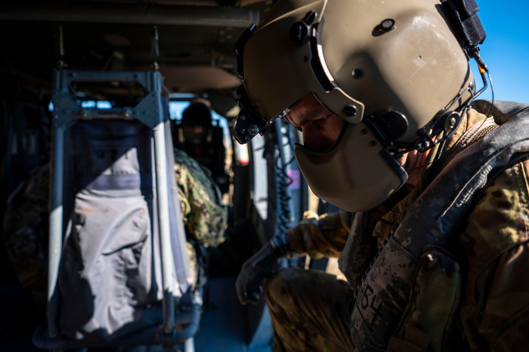 An aircrew member assigned to Golf Company, 5th Battalion, 159th Aviation Regiment, assists Operation Blue Horizon participants during a simulated aeromedical evacuation on a UH-60 Black Hawk at MacDill Air Force Base, Florida. (Airman 1st Class Alicia Campbell)
