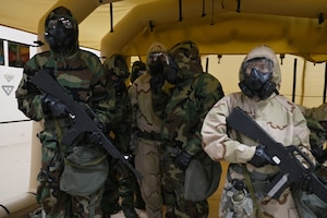 Airmen wear Mission Oriented Protective Posture gear and perform job duties.
