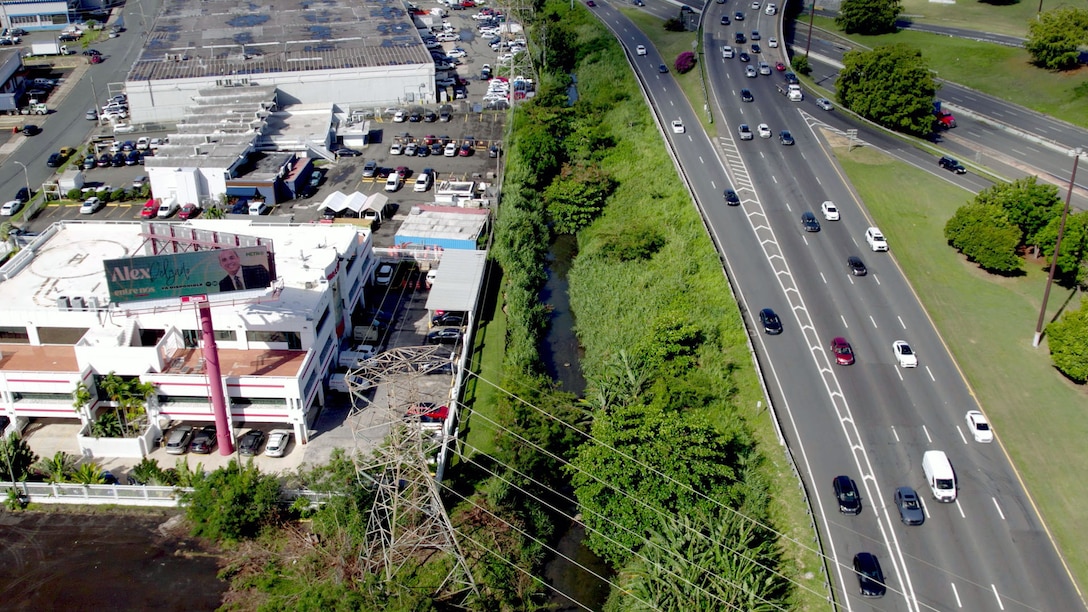 Aerial view of a river running through an industrial complex and expressway.