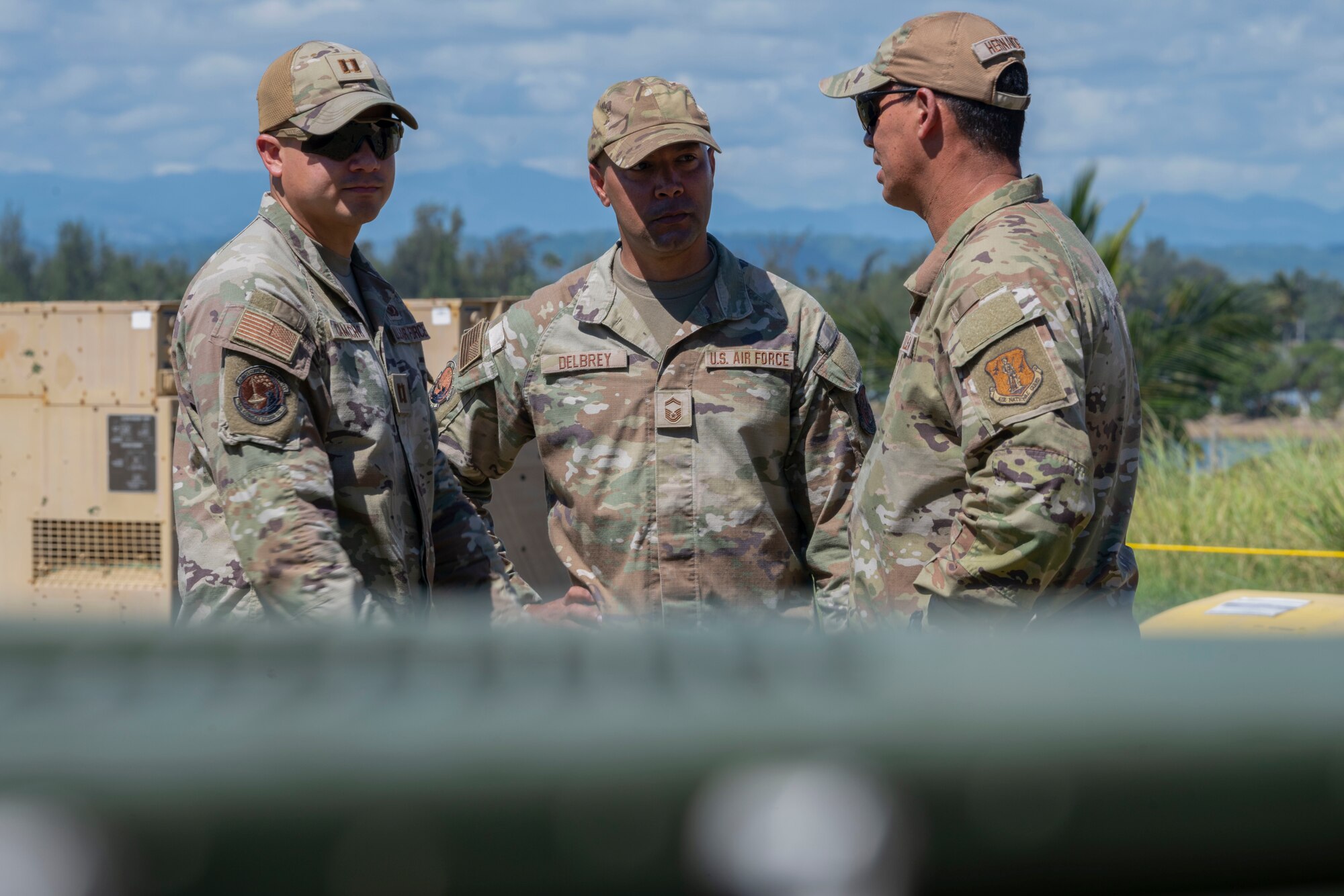 From left, U.S. Air Force Capt. Carlos Camacho, the cyber warfare officer in charge, Senior Master Sgt. Jonathan Delbrey, the cyber operations superintendent, and Chief Master Sgt. Medwin Hernandez, the senior enlisted leader, all with the 156th Combat Communications Squadron, Puerto Rico Air National Guard, speak during a Full Operating Capability (FOC) evaluation at Punta Salinas Air National Guard Station, Toa Baja, Puerto Rico, April 24, 2025. A team of approximately 25 Airmen assigned to the 156th CBCS were evaluated on their level of proficiency in providing NIPR, SIPR, and VOIP services in an expeditionary setting as part of the FOC certification process. (U.S. Air National Guard photo by Senior Airman Victoria Jewett)