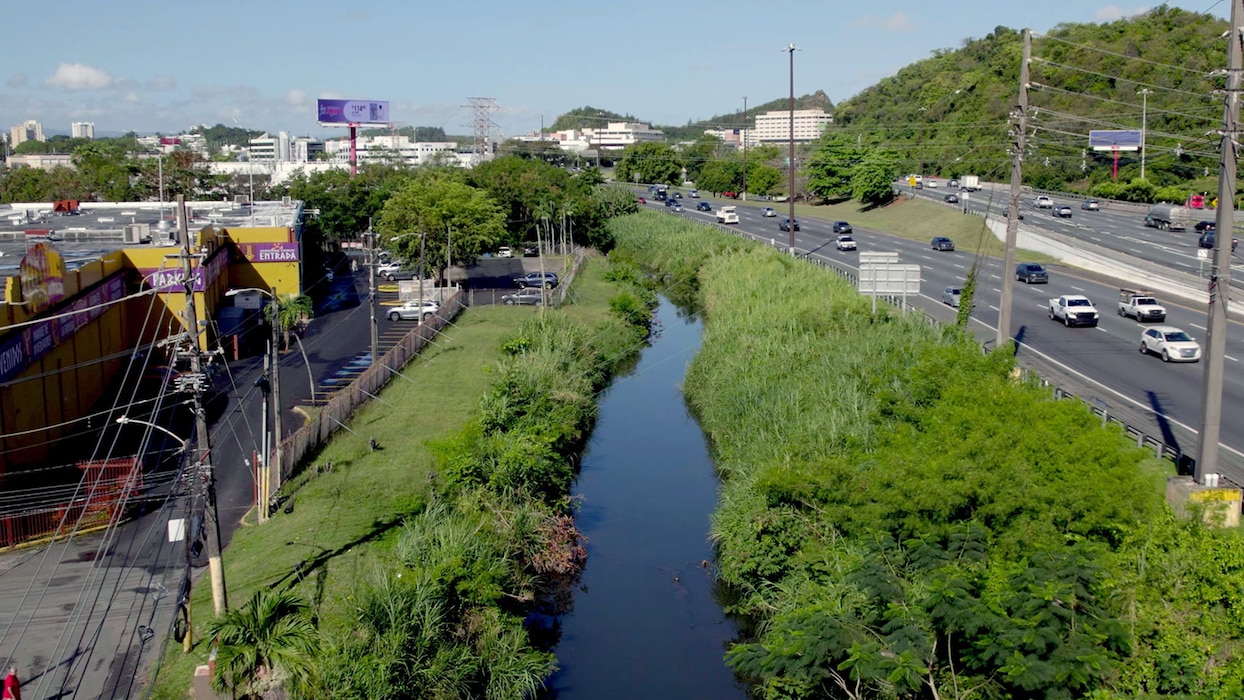 Aerial view of a river running through an industrial complex and expressway.