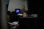 U.S. Air Force Maj. Angelo Tapalla, 196th Attack Squadron, California Air National Guard, grades members of the 15th Attack Squadron, Creech Air Force Base, Nev., during Reaper Smoke, March Air Reserve Base, Calif., April 23, 2025.