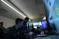 U.S. Air Force Master Sgt. Matthew Lynn and Maj. Angelo Tapalla, 196th Attack Squadron, California Air National Guard, review the tactical scenario details during Reaper Smoke, March Air Reserve Base, Calif., April 23, 2025.