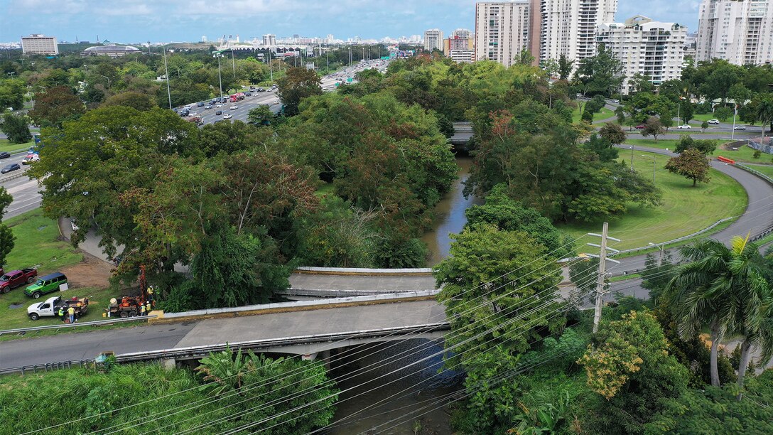 Aerial view of several bridges crossing a river near an expressway.