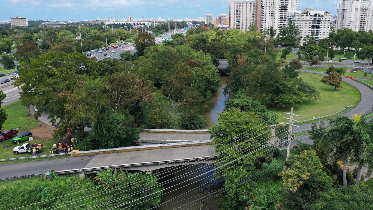Aerial view of several bridges crossing a river near an expressway.