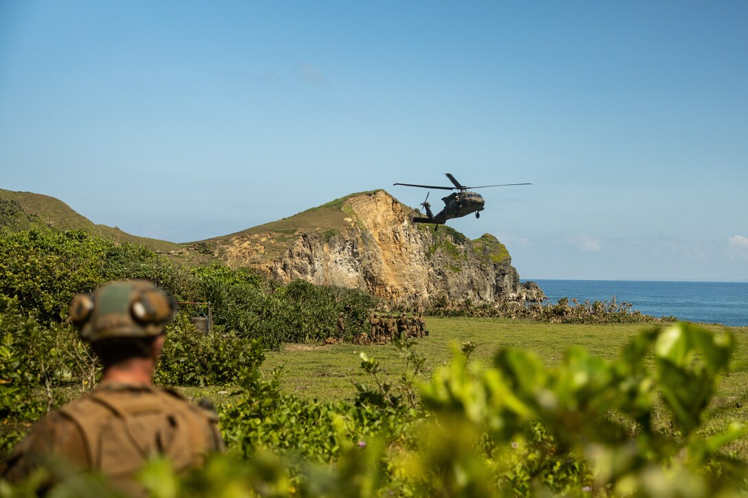 A U.S. Army UH-60 Black Hawk with 25th Combat Aviation Brigade, 25th Infantry Division, prepares to land while transporting U.S. Marines with 3d Littoral Combat Team, 3d Marine Littoral Regiment, 3d Marine Division, and Philippine Marines with Marine Battalion Landing Team 10, to the Batanes island chain for the Maritime Key Terrain Security Operations event during Exercise Balikatan 25 in the Philippines, April 24, 2025. Balikatan is a longstanding annual exercise between the Armed Forces of the Philippines and U.S. military designed to strengthen our ironclad alliance, improve our capable combined force, and demonstrate our commitment to regional security and stability. (U.S. Marine Corps photo by Cpl. Malia Sparks)
