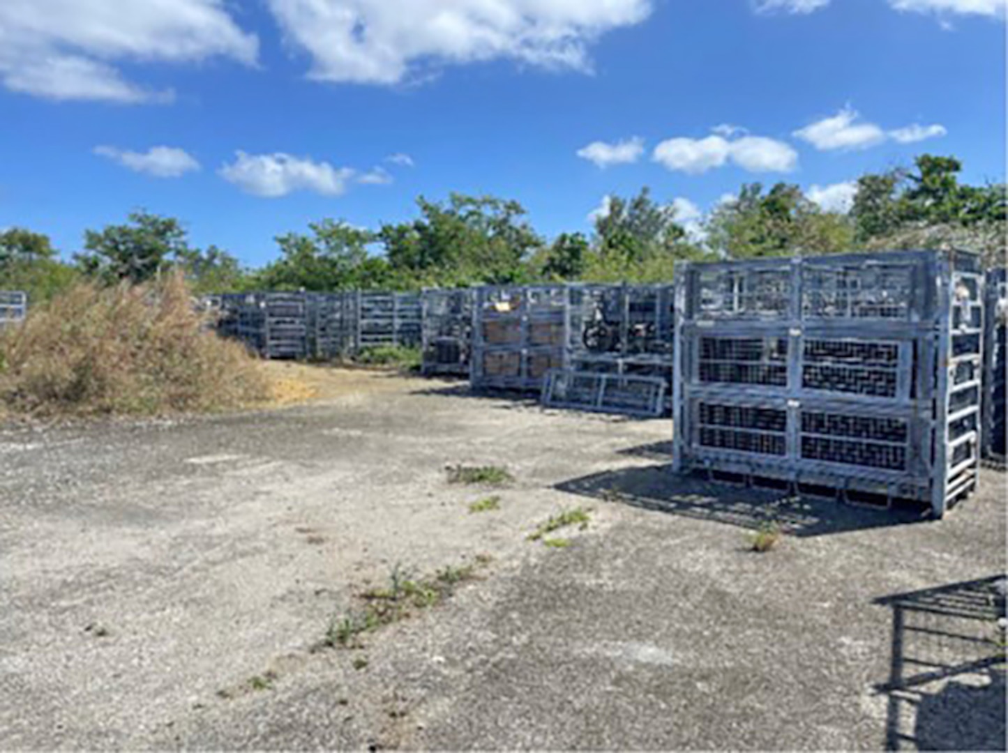 Metal containers sitting on a concrete pad outdoors.