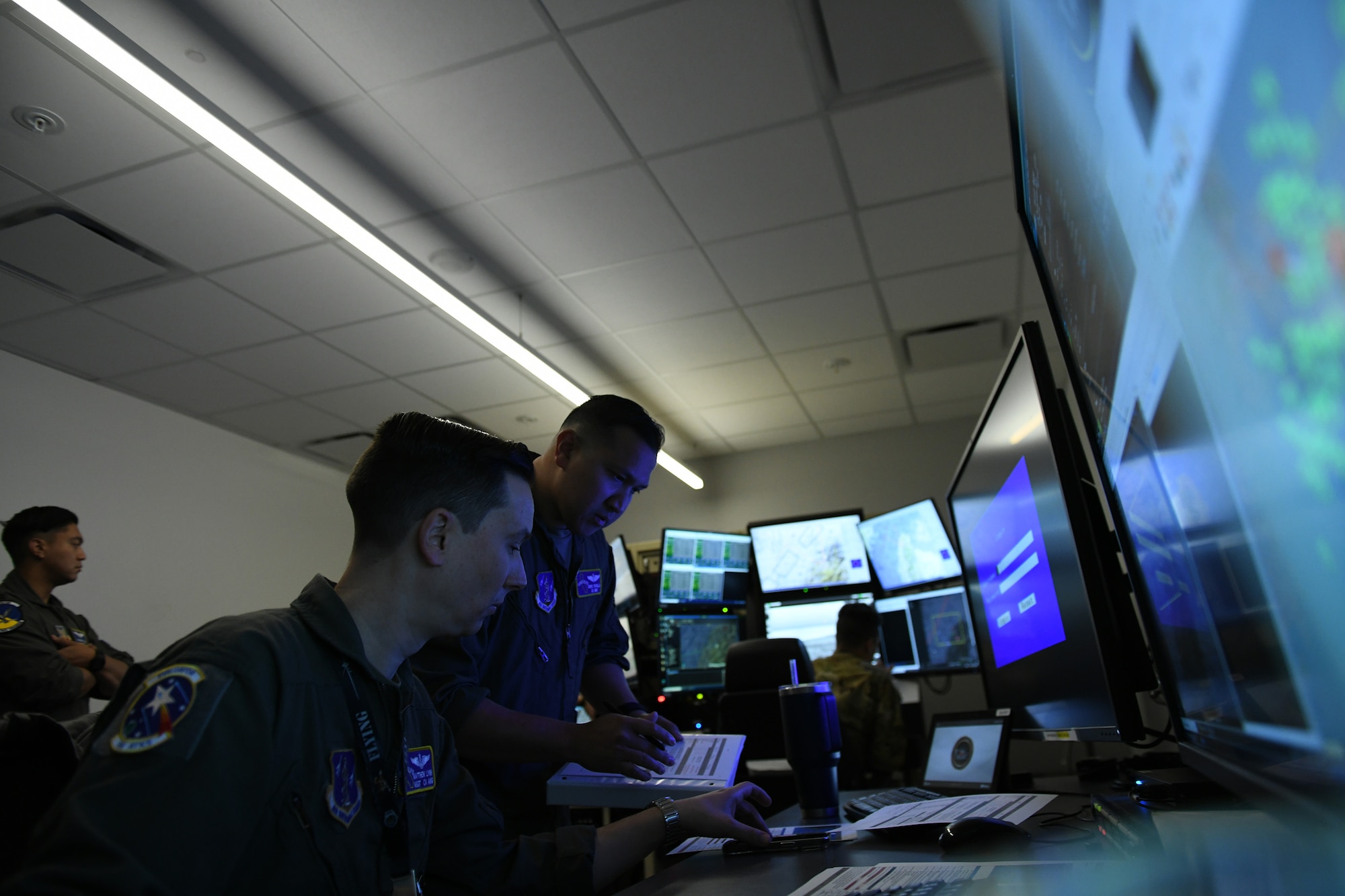 U.S. Air Force Master Sgt. Matthew Lynn and Maj. Angelo Tapalla, 196th Attack Squadron, California Air National Guard, review the tactical scenario details during Reaper Smoke, March Air Reserve Base, Calif., April 23, 2025.