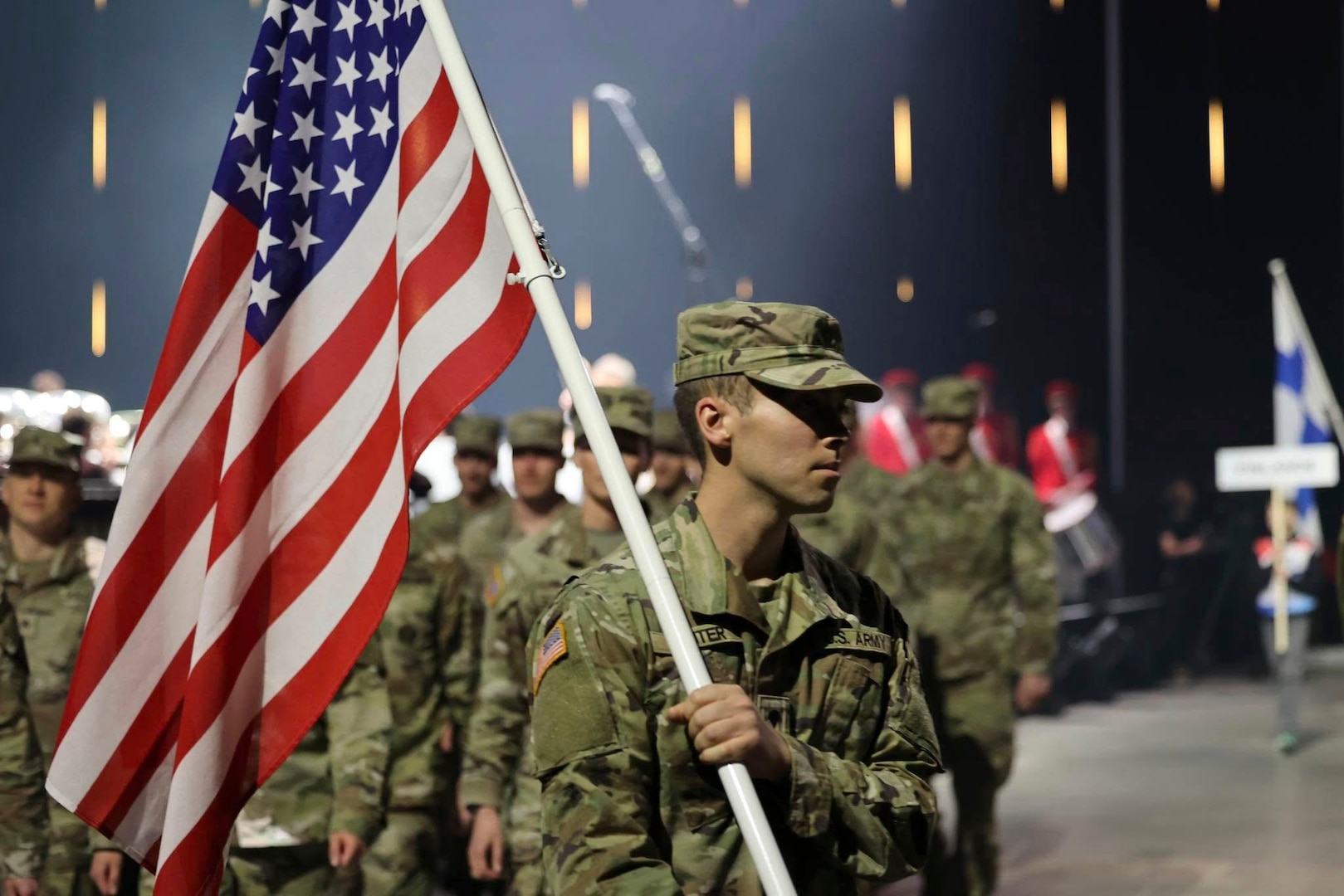 U.S. Army Spc. Caleb Hunter, Maine National Guard, leads team U.S.A. with the flag over his shoulder during the opening ceremony of the CISM 2025 World Winter Military Games