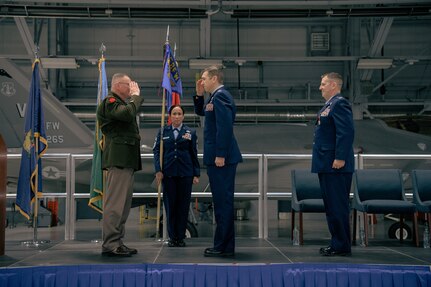 Vermont Army National Guard Maj. Gen. Greg Knight, the adjutant general of Vermont, salutes Col. Michael Blair after taking command of the Vermont Air National Guard's 158th Fighter Wing from Col. Daniel Finnegan, outgoing commander of the 158th, during a change of command ceremony