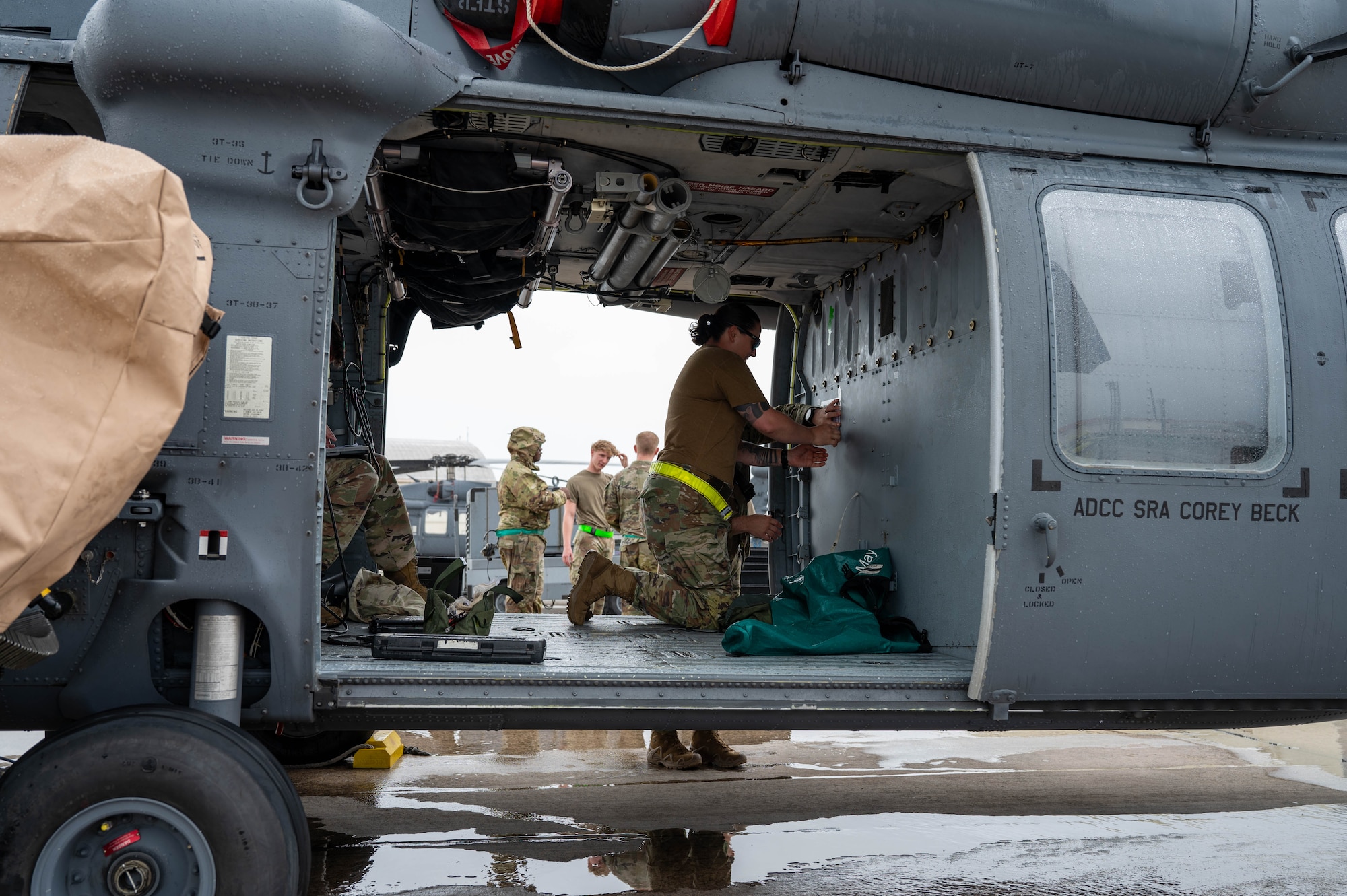 A U.S. Air Force Airman sits in an HH-60W Jolly Green II.