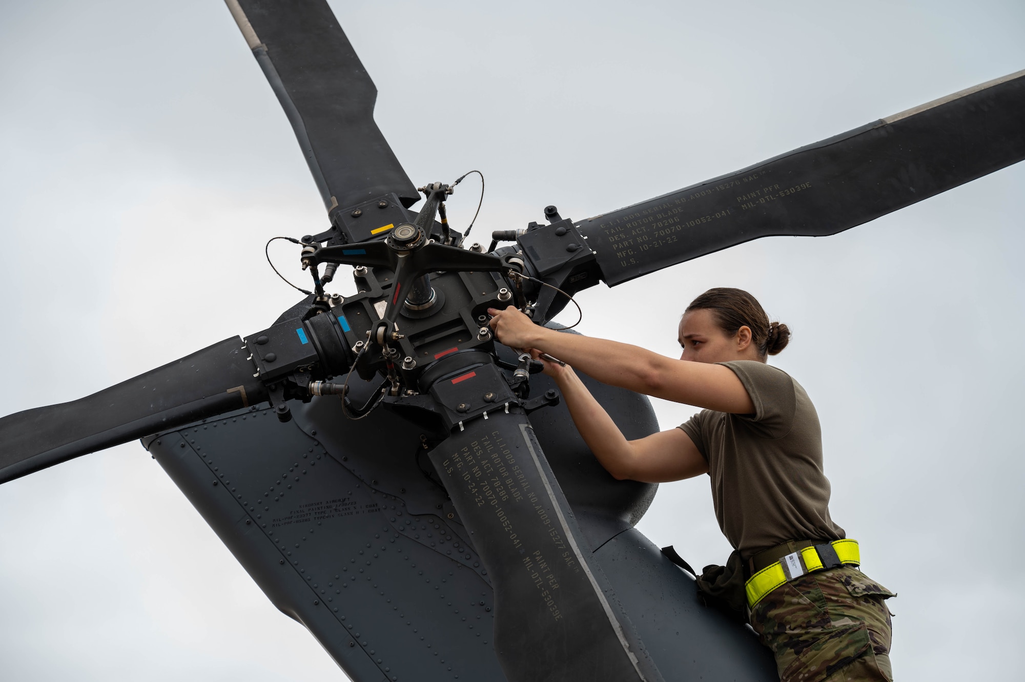 A U.S. Air Force Airman fixes a helicopter tail blade.