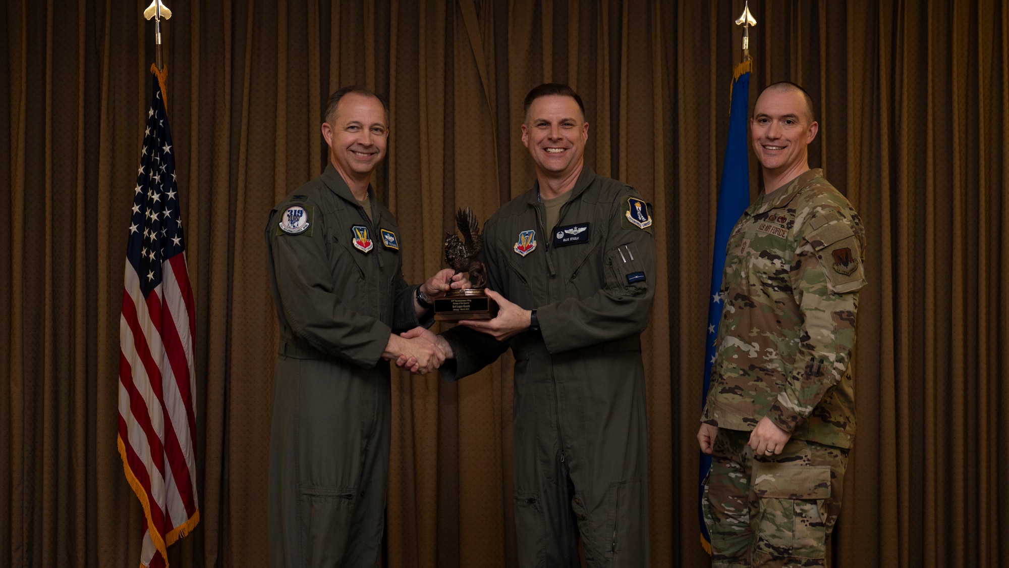 Col. Eric Steele, 319th Operations Group Commander accepts the Airman the Quarter Award on behalf of Senior Airman Logan Kuszik, 18th Airborne Command Control Center, during the 319th Reconnaissance Wing’s 1st quarter award ceremony at Grand Forks Air Force Base, North Dakota, May 2, 2025.