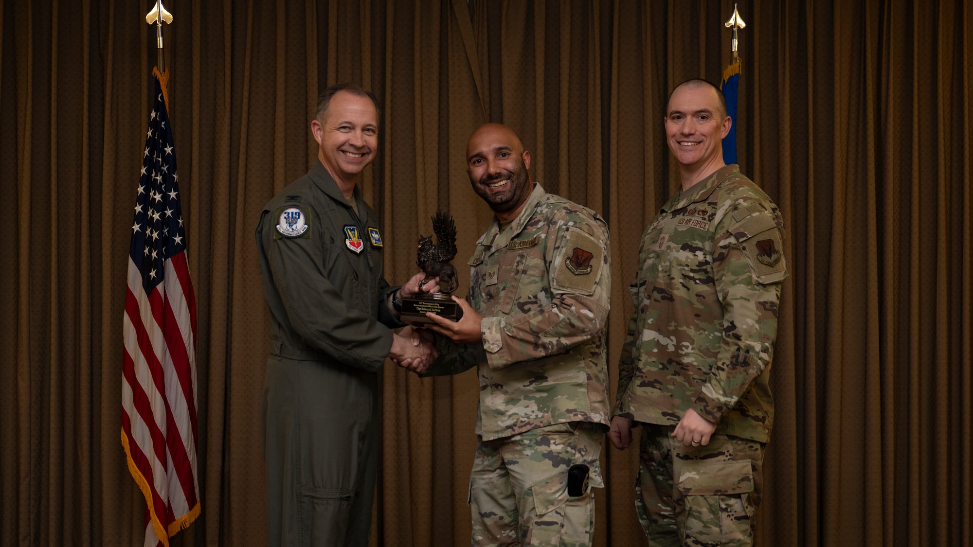 Staff Sgt. Robert Cochran, the NCOIC of Pass and Registration, accepts the Non-commissioned Officer of the Quarter Award on behalf of Technical Sgt. Rebecca J. Cochran, 319th Security Forces Squadron, during the 319th Reconnaissance Wing’s 1st quarter award ceremony at Grand Forks Air Force Base, North Dakota, May 2, 2025.
