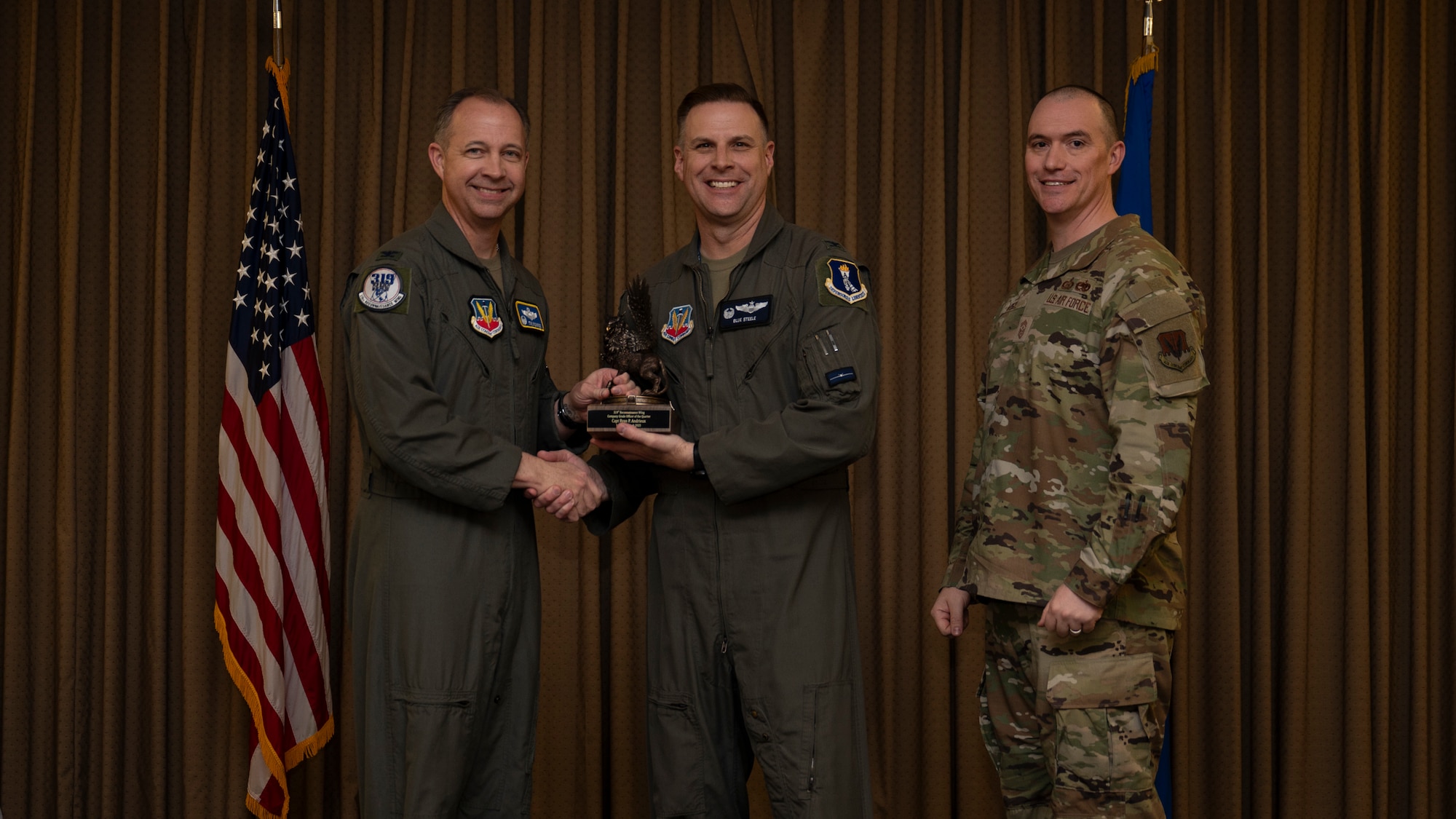 Col. Eric Steele, 319th Operations Group Commander, accepts the Company Grade Officer of the Quarter Award on behalf of Capt. Ryan P. Andrieux, 18th Airborne Command Control Center, during the 319th Reconnaissance Wing’s 1st quarter award ceremony at Grand Forks Air Force Base, North Dakota, May 2, 2025.