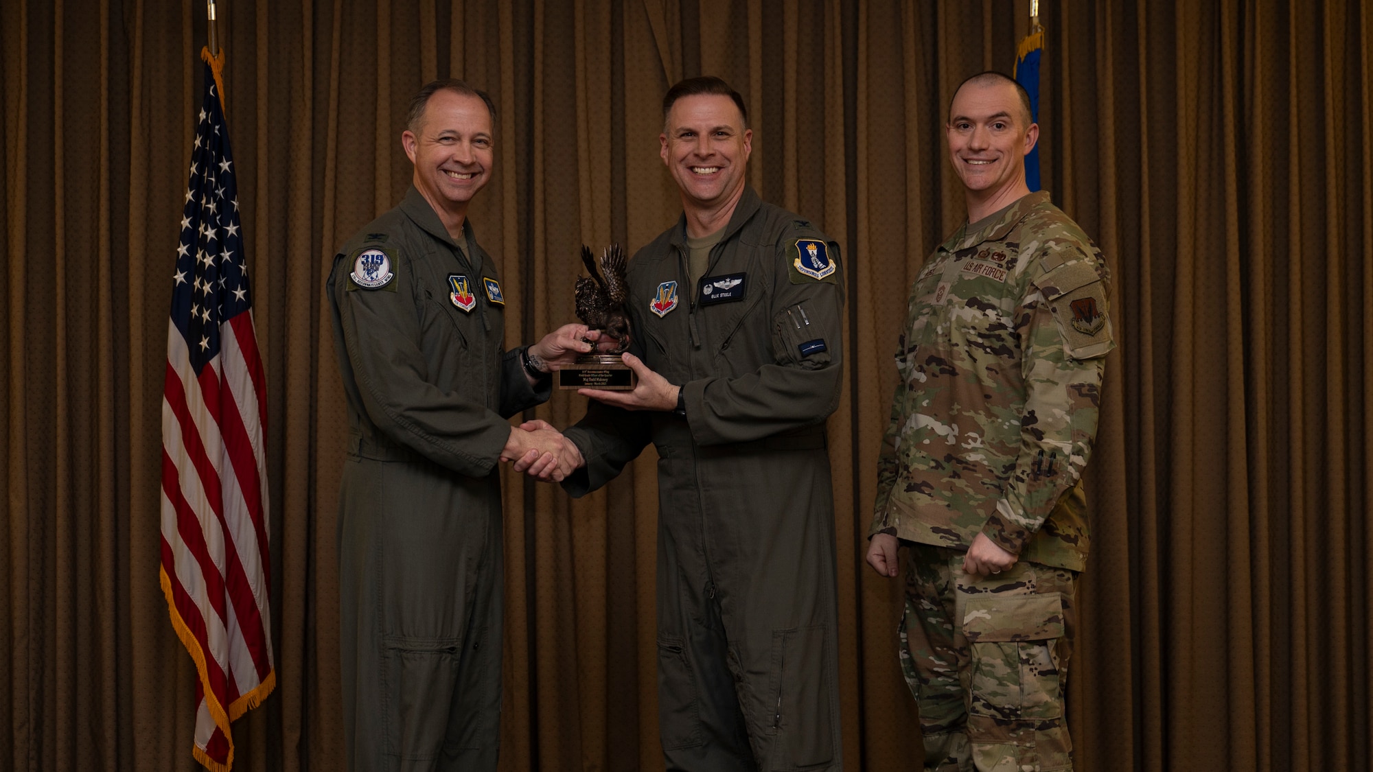 Col. Eric Steele, 319th Operations Group Commander, accepts the Field Grade Officer of the Quarter Award on behalf of Maj. Todd Maloney, 18th Airborne Command Control Center, during the 319th Reconnaissance Wing’s 1st quarter award ceremony at Grand Forks Air Force Base, North Dakota, May 2, 2025.