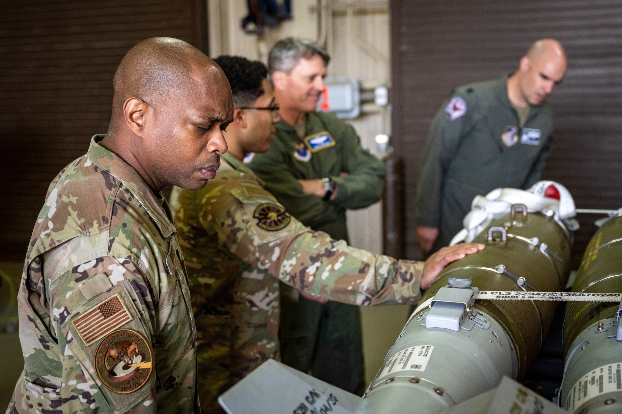 U.S. Air Force Chief Master Sgt. Ronnie Woods, Eighth Air Force command chief, looks at a GBU-54 bomb during an immersion tour