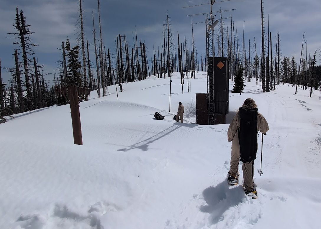 Willow Walker, a reservoir regulator, Water Management Section, Walla Walla District, U.S. Army Corps of Engineers, snowshoes through deep snow toward the Hemlock Butte SNOTEL (Snow Telemetry), 5,810 feet above sea level in the Clearwater National Forest, April 10. The SNOTEL station is designed to collect snowpack and related climatic data—crucial for forecasting regional water flow that sustains rivers, farms, and communities. These data collection points are part of the annual snow flight, which USACE conducts in collaboration with the Idaho Natural Resources Conservation Service, U.S. Department of Agriculture.