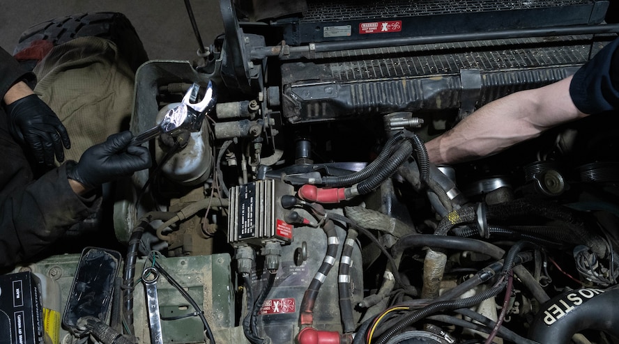 Airmen assigned to the 5th Logistics Readiness Squadron vehicle maintenance flight replace parts on a High Mobility Multipurpose Wheeled Vehicle (Humvee) alternator at Minot Air Force Base, North Dakota, April 30, 2025. The Humvee has a maximum speed of 70 mph depending on the configuration and has an effective range of 300 miles. (U.S. Air Force photo by Airman 1st Class Wesley Davies)