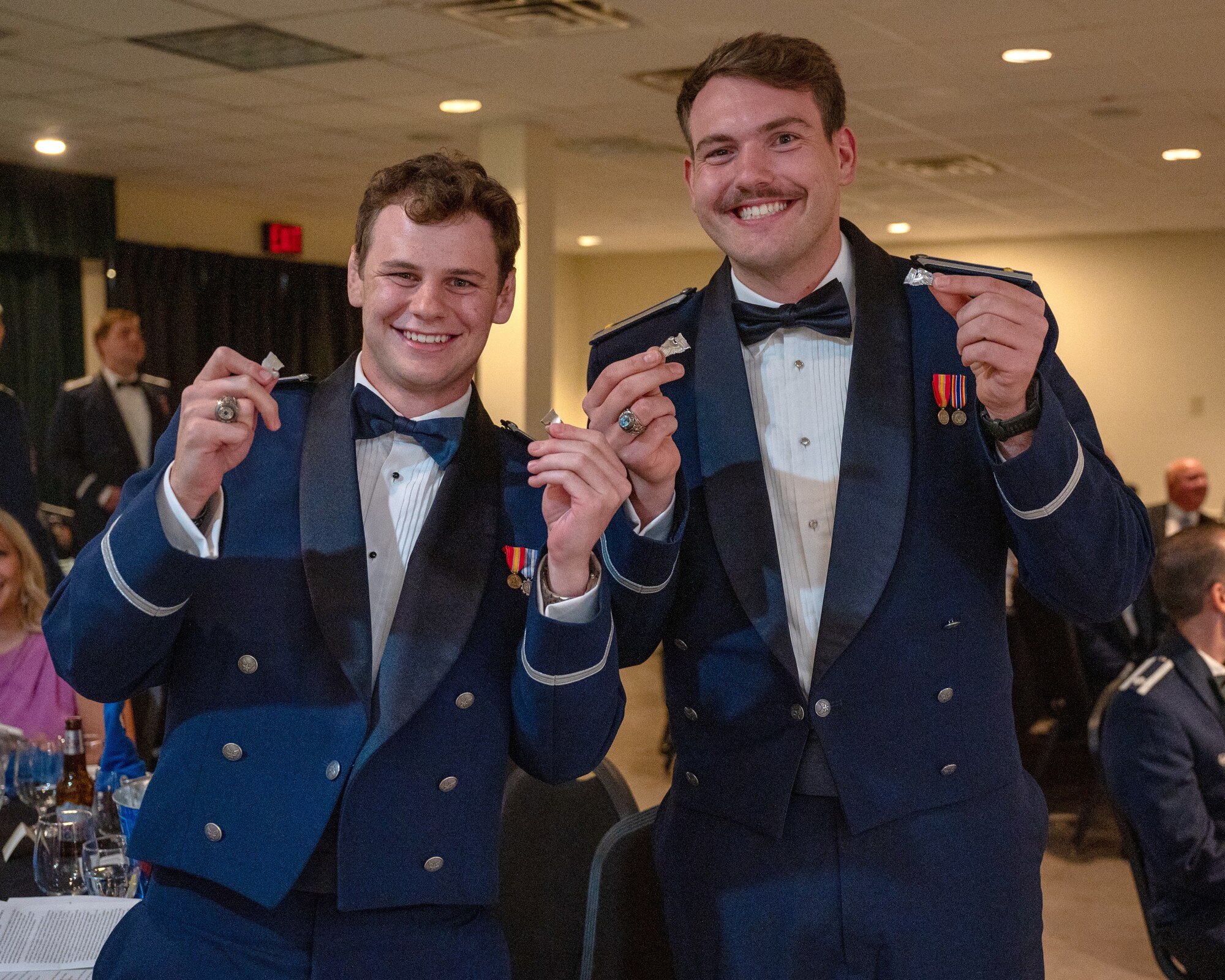 U.S. Air Force 2nd Lt. Nicholas Krug, left, 47th Student Squadron (STUS) pilot, and 2nd Lt. Ryan Keating, right, 47th STUS student pilot, show off their broken silver wings at Laughlin Air Force Base, Texas, May 1, 2025. The breaking of the wings is a tradition that reaches back to when the U.S. Army Air Corps first started issuing pilot wings, tradition states that the first pair of wings given are not to be worn, but broken and given to a loved one, with the 2 two halves not to be reunited until the next life. (U.S. Air Force photo by Staff Sgt. Nicholas Larsen)