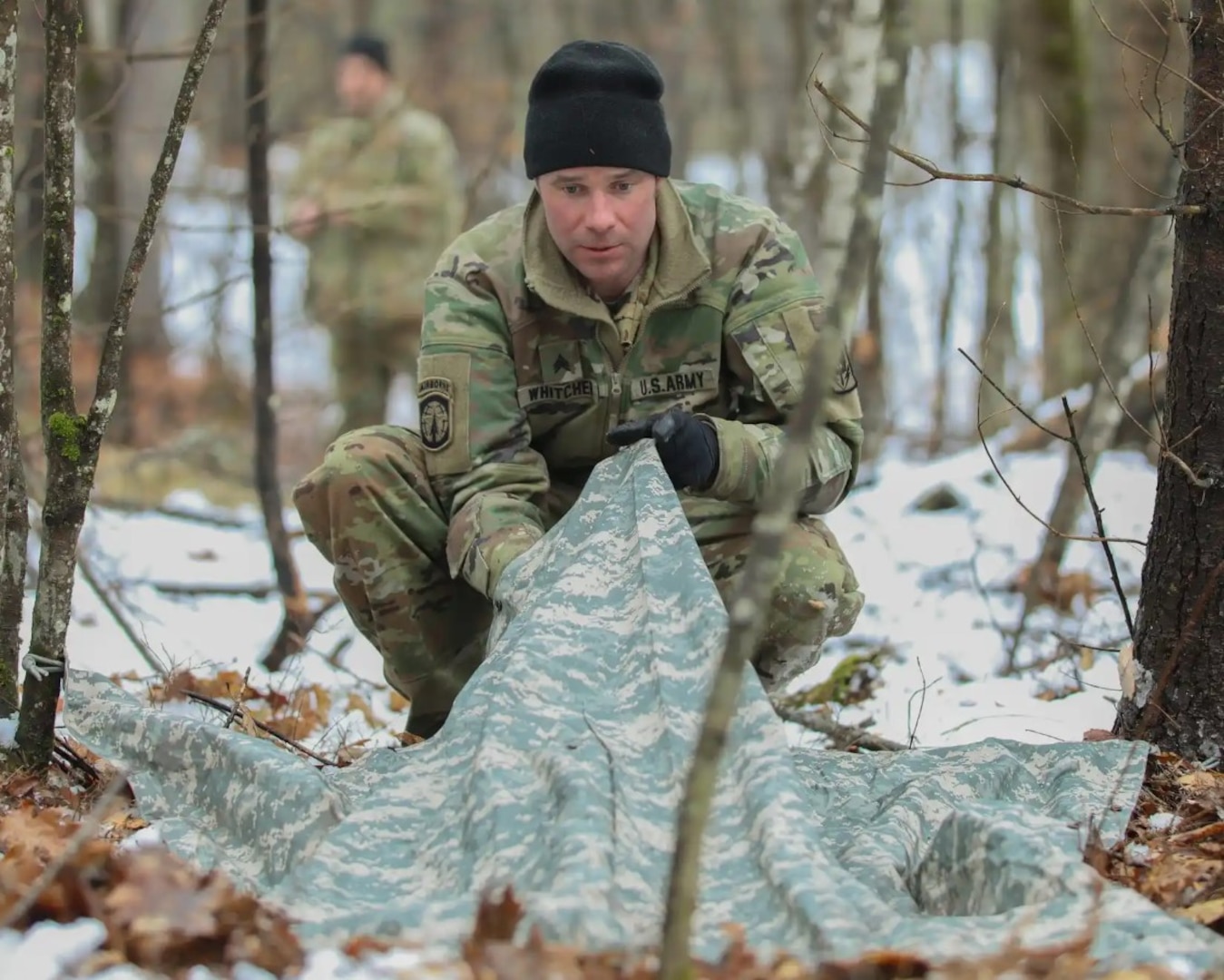 Sgt. Matthew Witcher, a fuel supply specialist with Charlie Company, 3rd Battalion, 238th Aviation Regiment (MEDEVAC), builds a shelter during a search and rescue field training exercise April 12, 2025, at the Edward Cross Training Complex in Pembroke. Soldiers from the NHARNG company practiced building shelters during a final evasion tactics event.