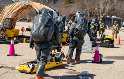 Soldiers from the 12th Civil Support Team, New Hampshire National Guard, transfer a notional victim to a decontamination line during a chemical, biological, radiological, and nuclear response exercise April 9, 2025, at Storyland in Glen, N.H.