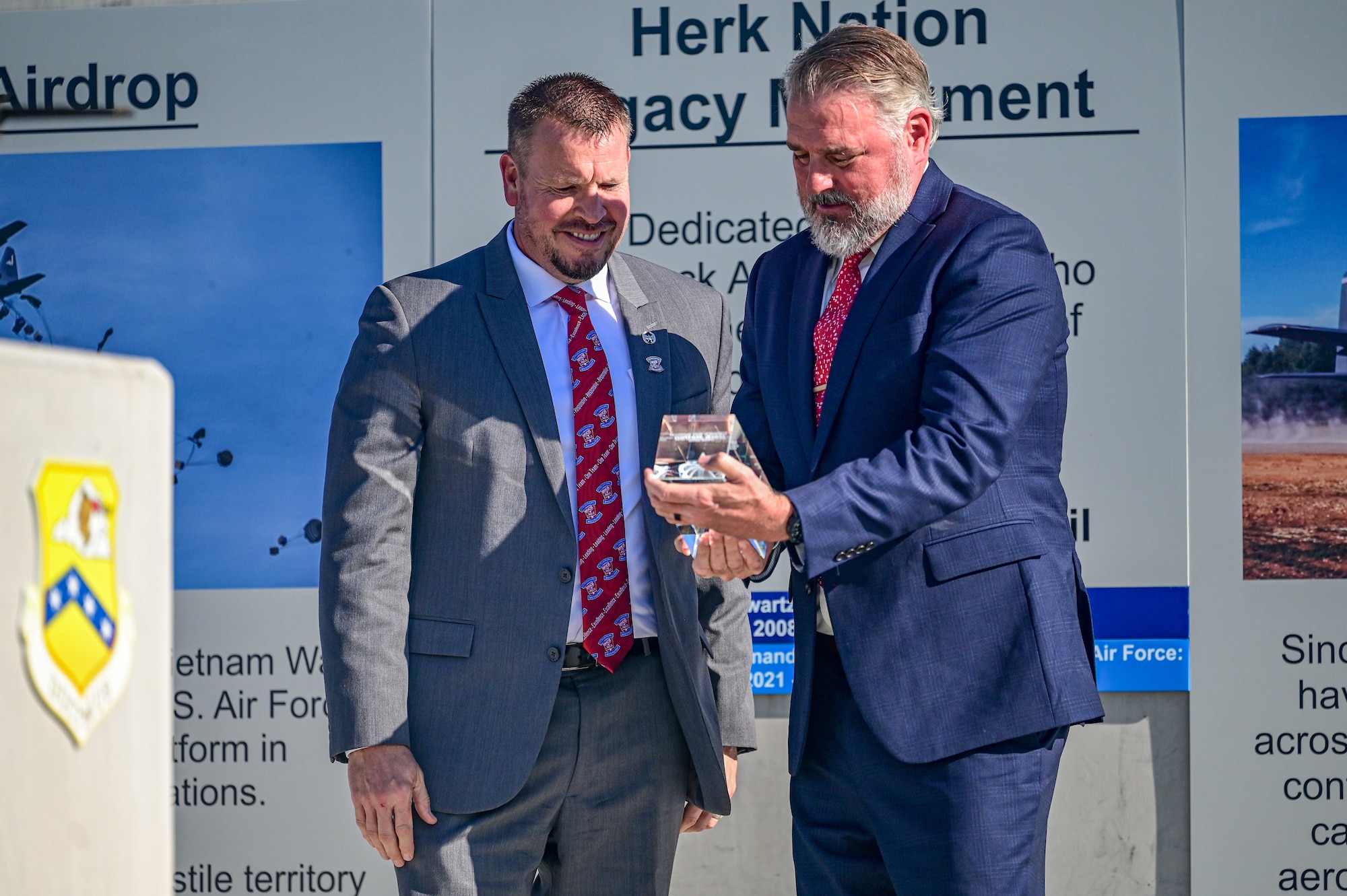 Two people look at an award.