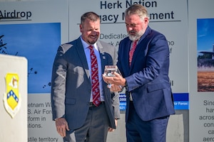 Two people look at an award.