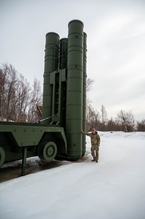 U.S. Air Force Staff Sgt. Kjell Olson, 354th Range Squadron plans and programs non-commissioned officer, stands next to a range target at Eielson Air Force Base, Alaska, April 16, 2025.